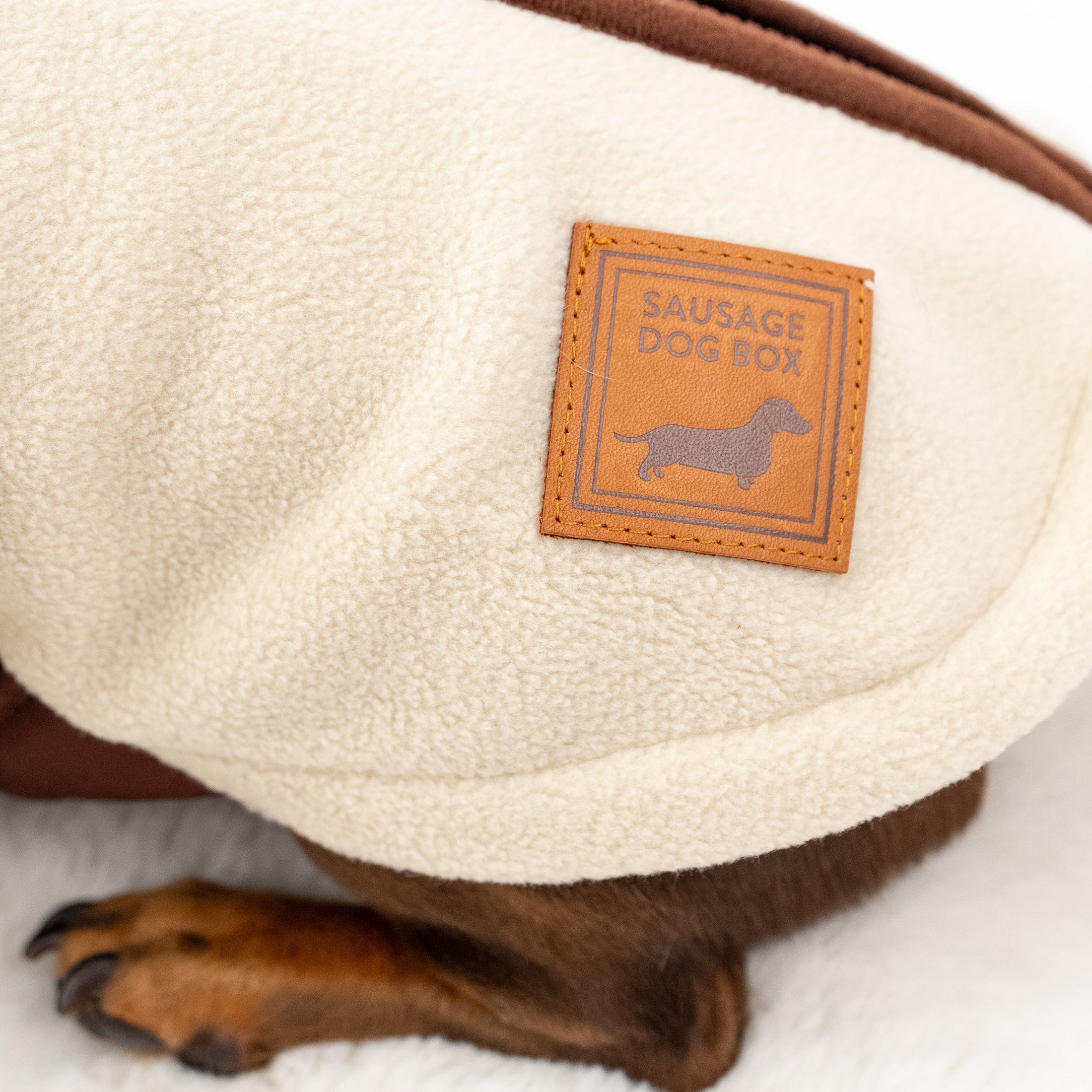 Close up of cream DoxieDri Dachshund fleece with Sausage Dog Box branded patch