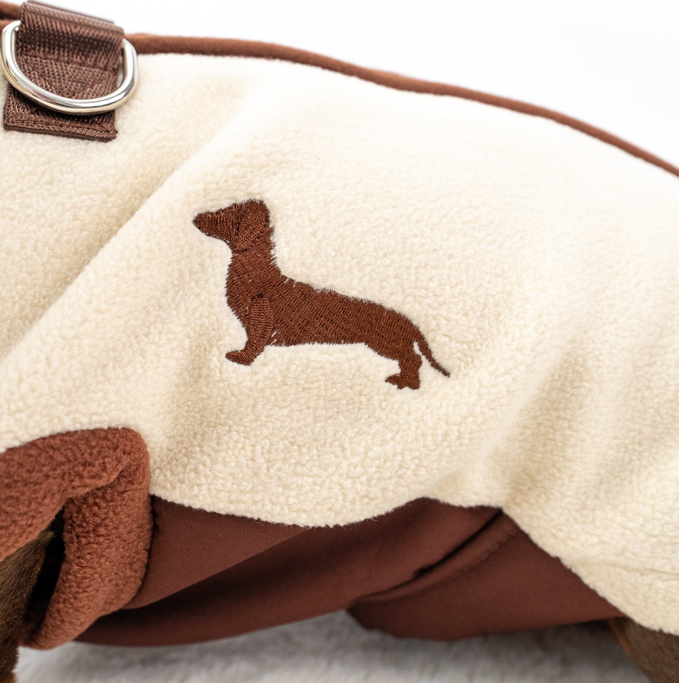 Close up of cream DoxieDri water resistant fleece with brown Dachshund embroidery